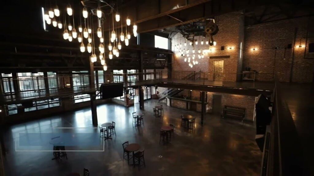 Aerial interior view of an event space with hanging Edison bulb chandeliers and lounge seating